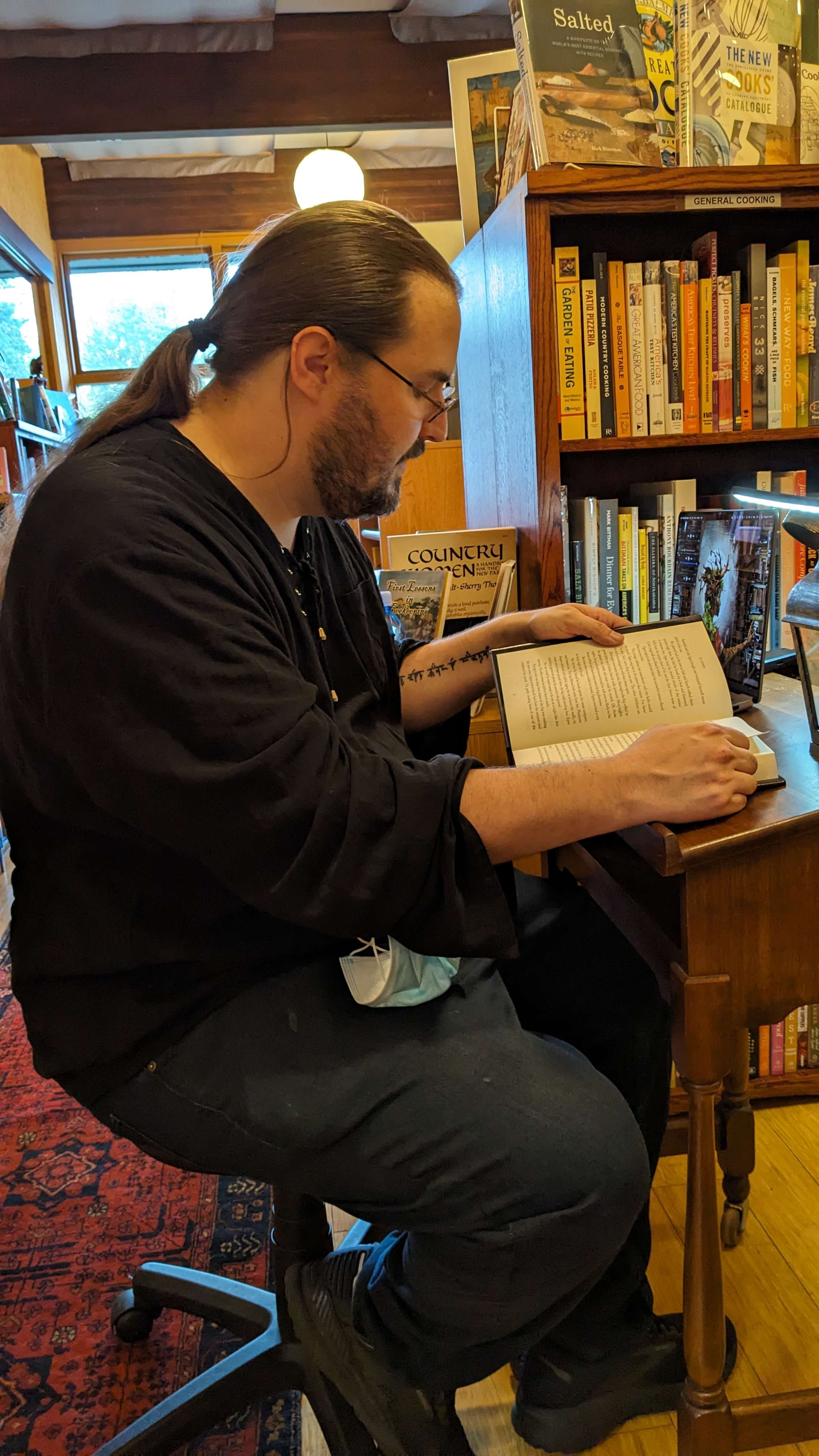 Author T.H. Lehnen reading from Fog & Firefles at a small lectern at Chaparral Books on April 4th, 2024.